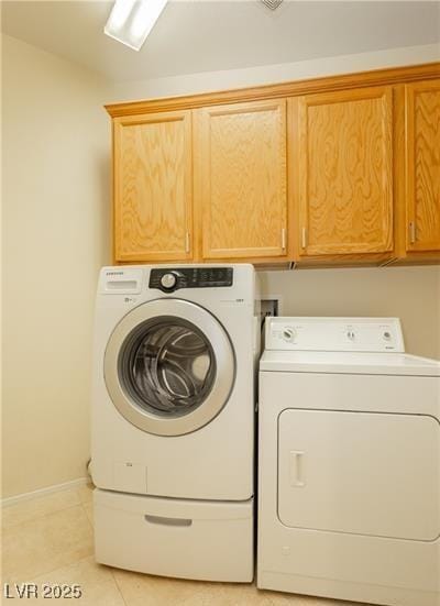 laundry room featuring cabinet space, independent washer and dryer, and light tile patterned floors