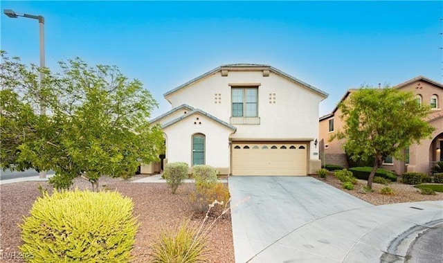 mediterranean / spanish home with an attached garage, driveway, and stucco siding