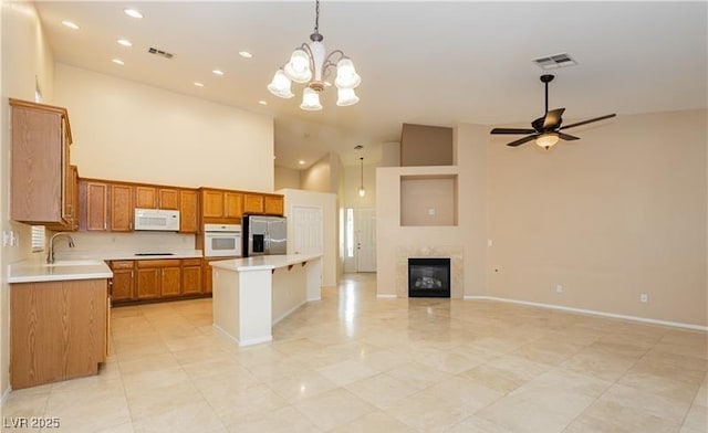 kitchen with open floor plan, light countertops, white appliances, and hanging light fixtures