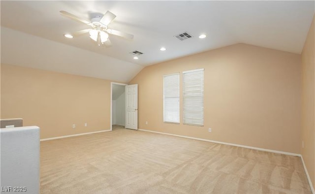 spare room featuring lofted ceiling, visible vents, and baseboards