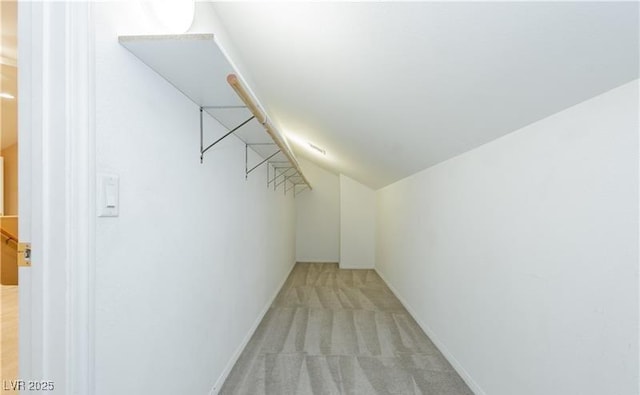 spacious closet featuring lofted ceiling and light colored carpet