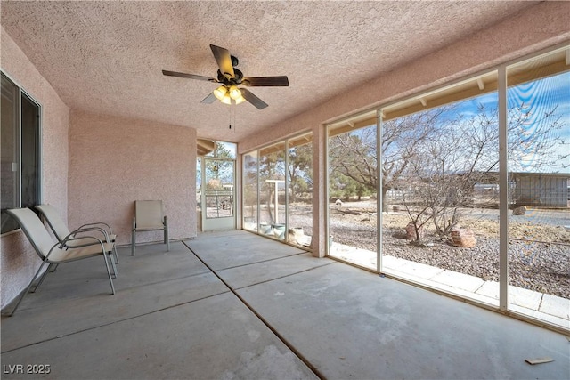 unfurnished sunroom with plenty of natural light and a ceiling fan