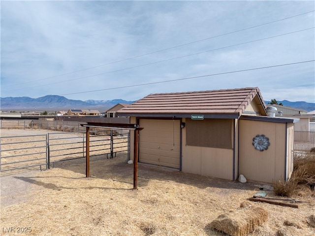 view of outdoor structure with fence, an outdoor structure, and a mountain view