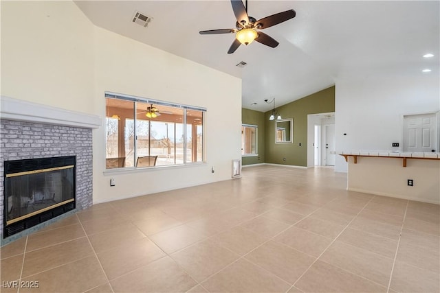 unfurnished living room with light tile patterned floors, baseboards, visible vents, a ceiling fan, and a brick fireplace