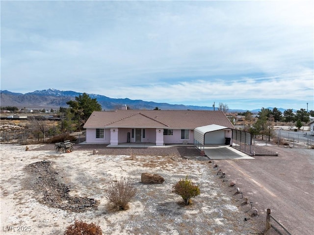 ranch-style home featuring driveway, an attached garage, a mountain view, and a tiled roof