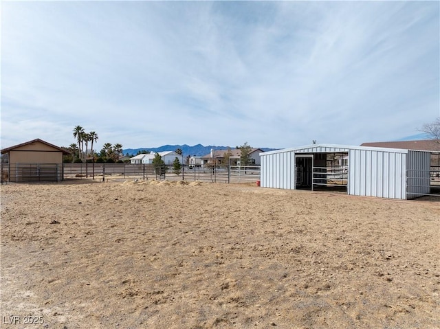 view of yard with an outbuilding, an exterior structure, and a mountain view