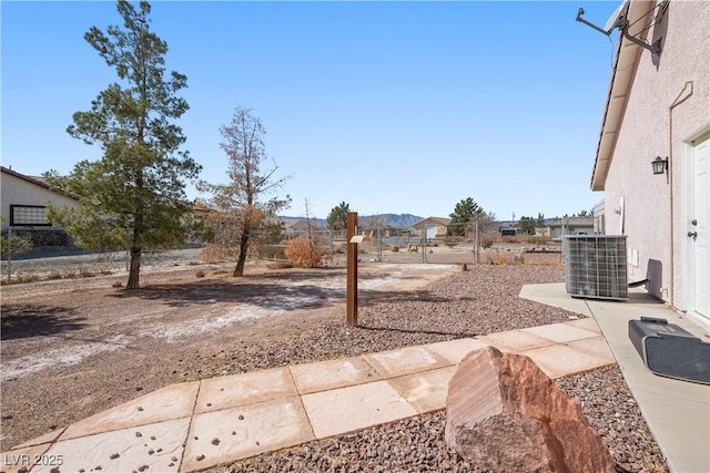 view of yard featuring a patio area, fence, and central AC unit