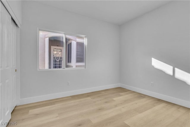 empty room with light wood-type flooring and baseboards