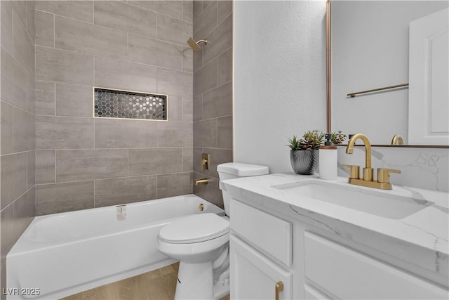 bathroom featuring toilet, wood finished floors, vanity, and bathing tub / shower combination