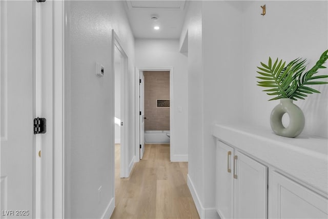 corridor featuring light wood finished floors and baseboards