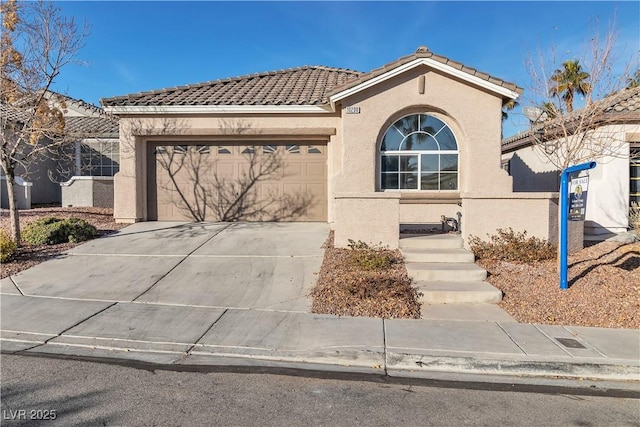 view of front facade featuring driveway, a tile roof, a garage, and stucco siding