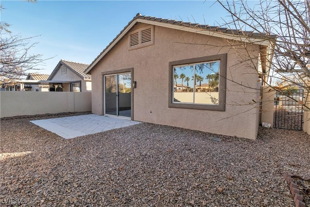 back of house featuring a patio area, fence, and stucco siding