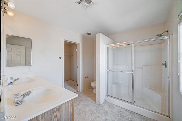 full bath with a stall shower, visible vents, a sink, and toilet