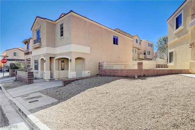 view of front of home with a fenced front yard, a residential view, and stucco siding