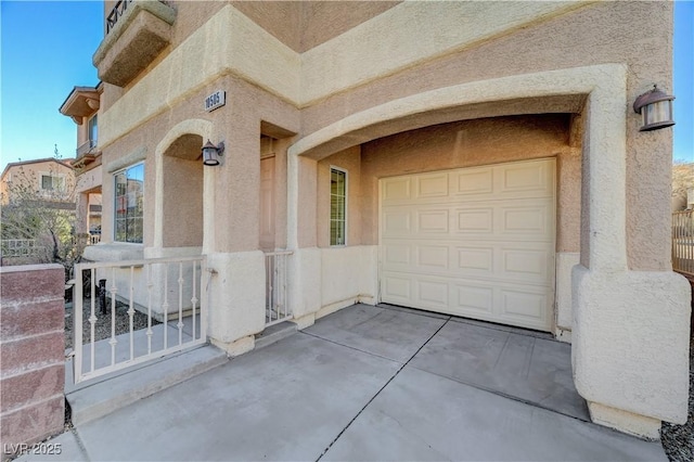 property entrance with a garage and stucco siding