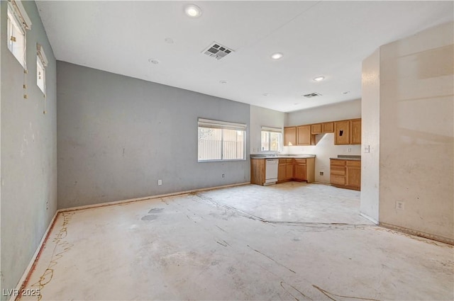 kitchen with baseboards, visible vents, brown cabinets, white dishwasher, and light countertops