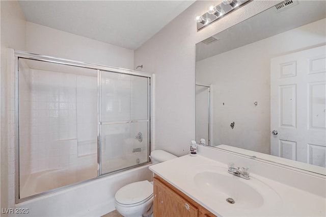 bathroom featuring toilet, visible vents, bath / shower combo with glass door, and vanity