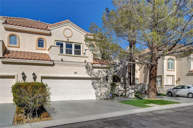 mediterranean / spanish-style house with driveway, a tiled roof, and stucco siding