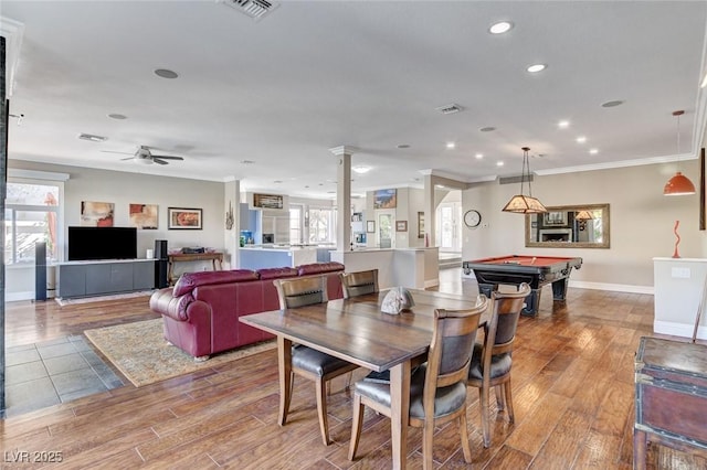 dining area featuring baseboards, visible vents, wood finished floors, and ornamental molding