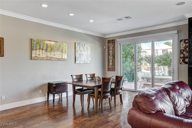 dining room with baseboards, dark wood-type flooring, and crown molding