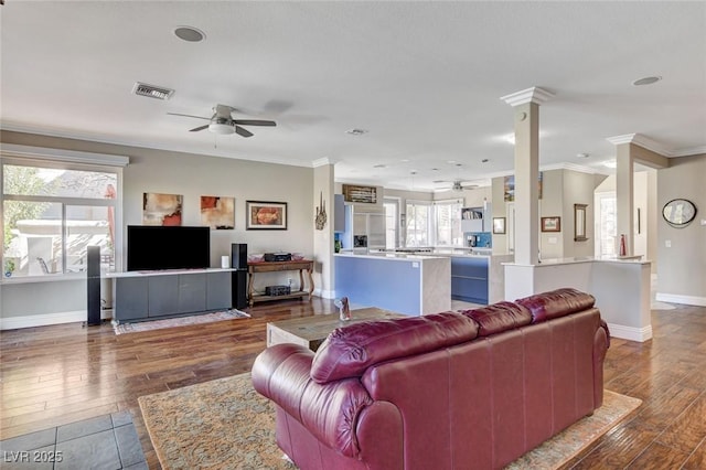 living room featuring visible vents, dark wood-type flooring, and ornamental molding