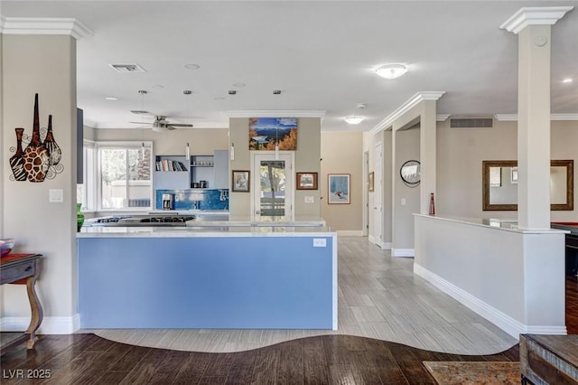 kitchen featuring visible vents, a ceiling fan, light wood-style flooring, ornamental molding, and light countertops