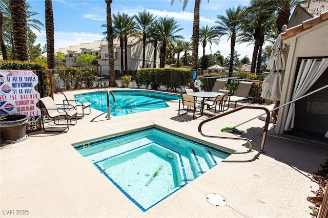 community pool featuring fence, a community hot tub, and a patio