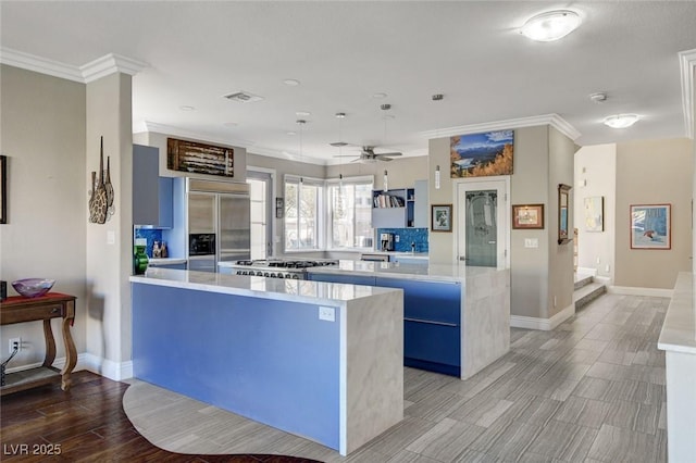 kitchen featuring built in fridge, crown molding, light countertops, light wood-style floors, and a kitchen island