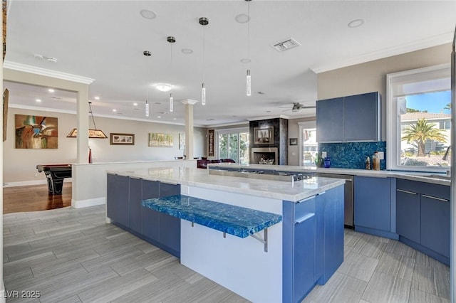 kitchen featuring a breakfast bar, visible vents, open floor plan, blue cabinetry, and a center island