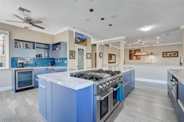 kitchen featuring range with two ovens, wine cooler, hanging light fixtures, blue cabinetry, and open shelves