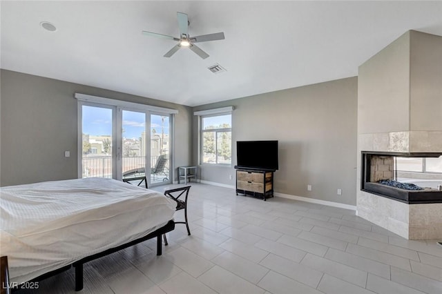 bedroom featuring baseboards, visible vents, a ceiling fan, a tiled fireplace, and access to outside