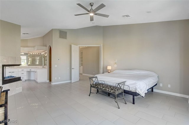 bedroom featuring lofted ceiling, arched walkways, visible vents, and baseboards