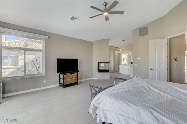 bedroom with baseboards, visible vents, vaulted ceiling, and a multi sided fireplace