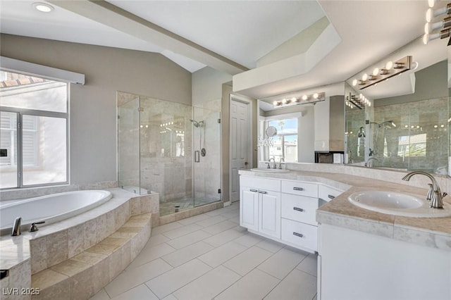 full bathroom featuring lofted ceiling, double vanity, a sink, and a bath