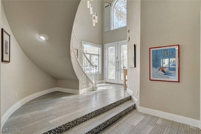 entryway with french doors, stairway, wood tiled floor, and baseboards