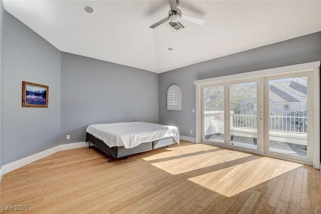 bedroom featuring access to outside, lofted ceiling, visible vents, light wood-type flooring, and baseboards