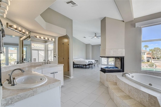 ensuite bathroom with a healthy amount of sunlight, a sink, and double vanity