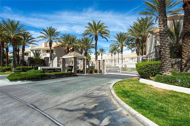 view of road with a residential view, a gate, curbs, and a gated entry