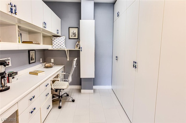 home office featuring light tile patterned floors, built in desk, and baseboards