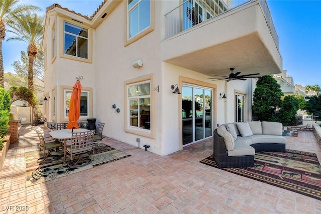 view of patio with a balcony, outdoor dining area, a ceiling fan, and an outdoor living space