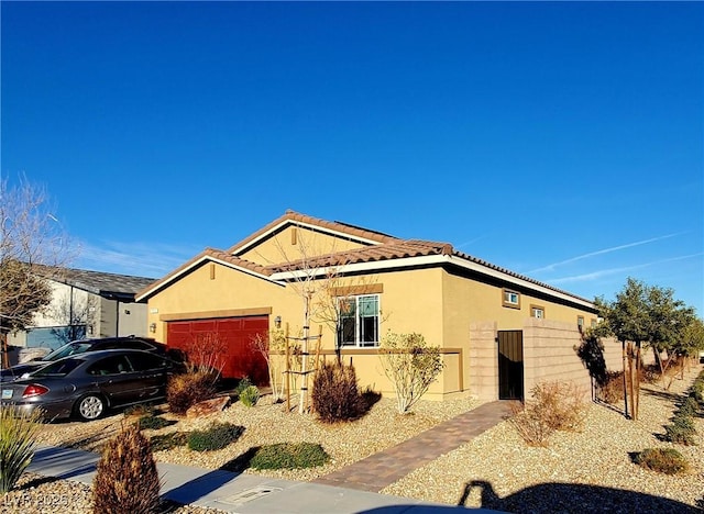 view of side of home with a tiled roof, an attached garage, and stucco siding