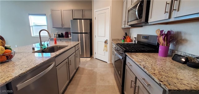 7910 Shimmery St, North Las Vegas, NV 89084 - kitchen with stainless steel appliances, a sink, gray cabinetry, and light stone countertops