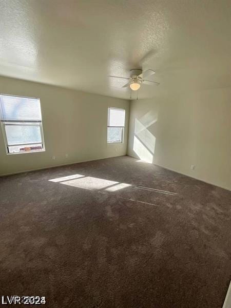 empty room with carpet floors, ceiling fan, and a textured ceiling