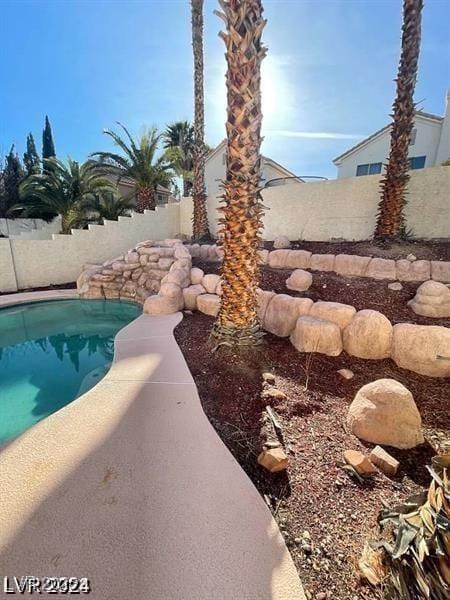 view of swimming pool with a fenced backyard and a fenced in pool