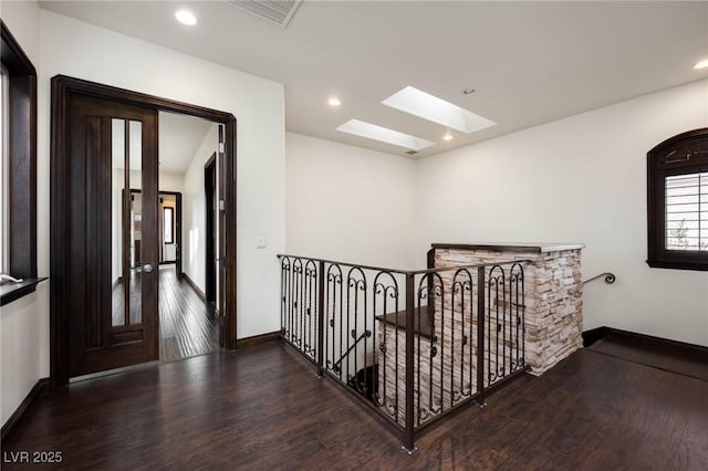 hall with a skylight, baseboards, visible vents, dark wood-type flooring, and recessed lighting