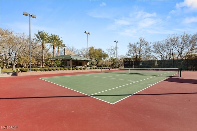 view of tennis court featuring community basketball court and fence