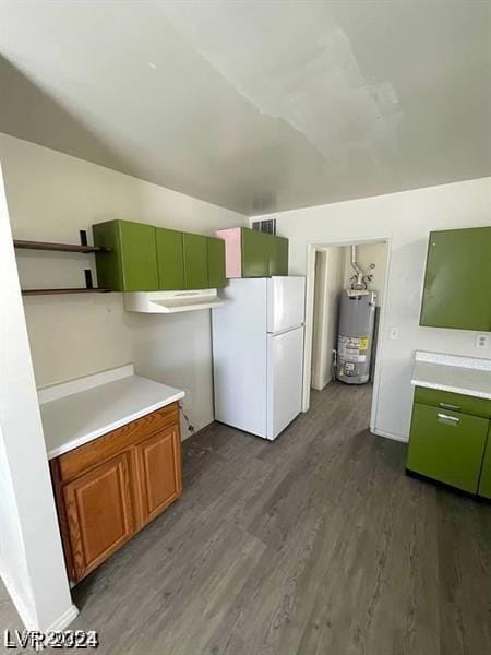 kitchen with light countertops, gas water heater, dark wood finished floors, and freestanding refrigerator