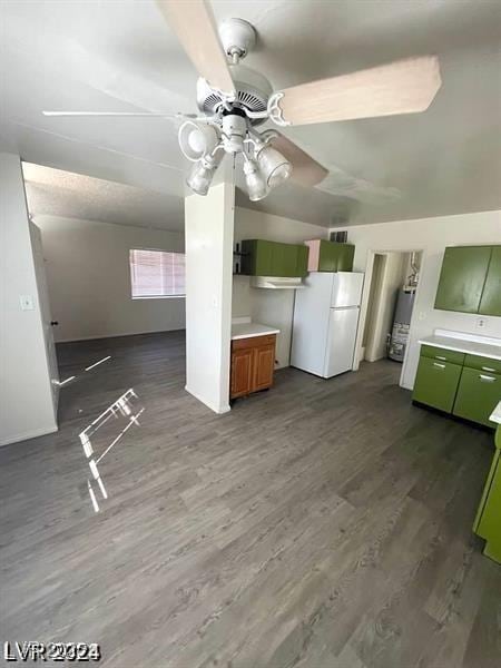 kitchen featuring gas water heater, wood finished floors, green cabinets, light countertops, and freestanding refrigerator