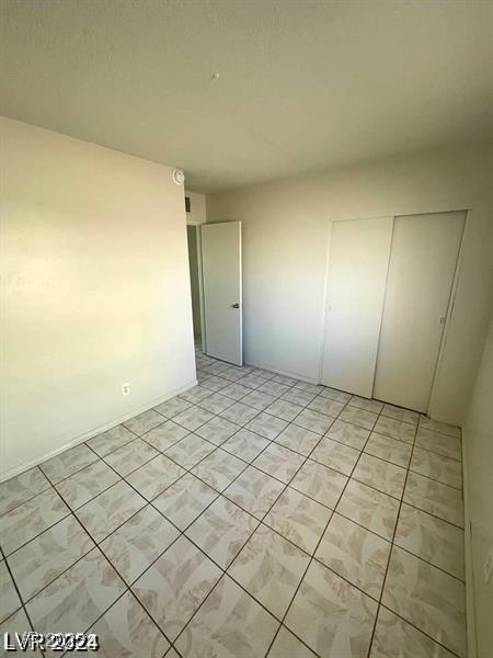 unfurnished bedroom with light tile patterned floors and a closet