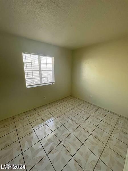 spare room with light tile patterned floors and a textured ceiling